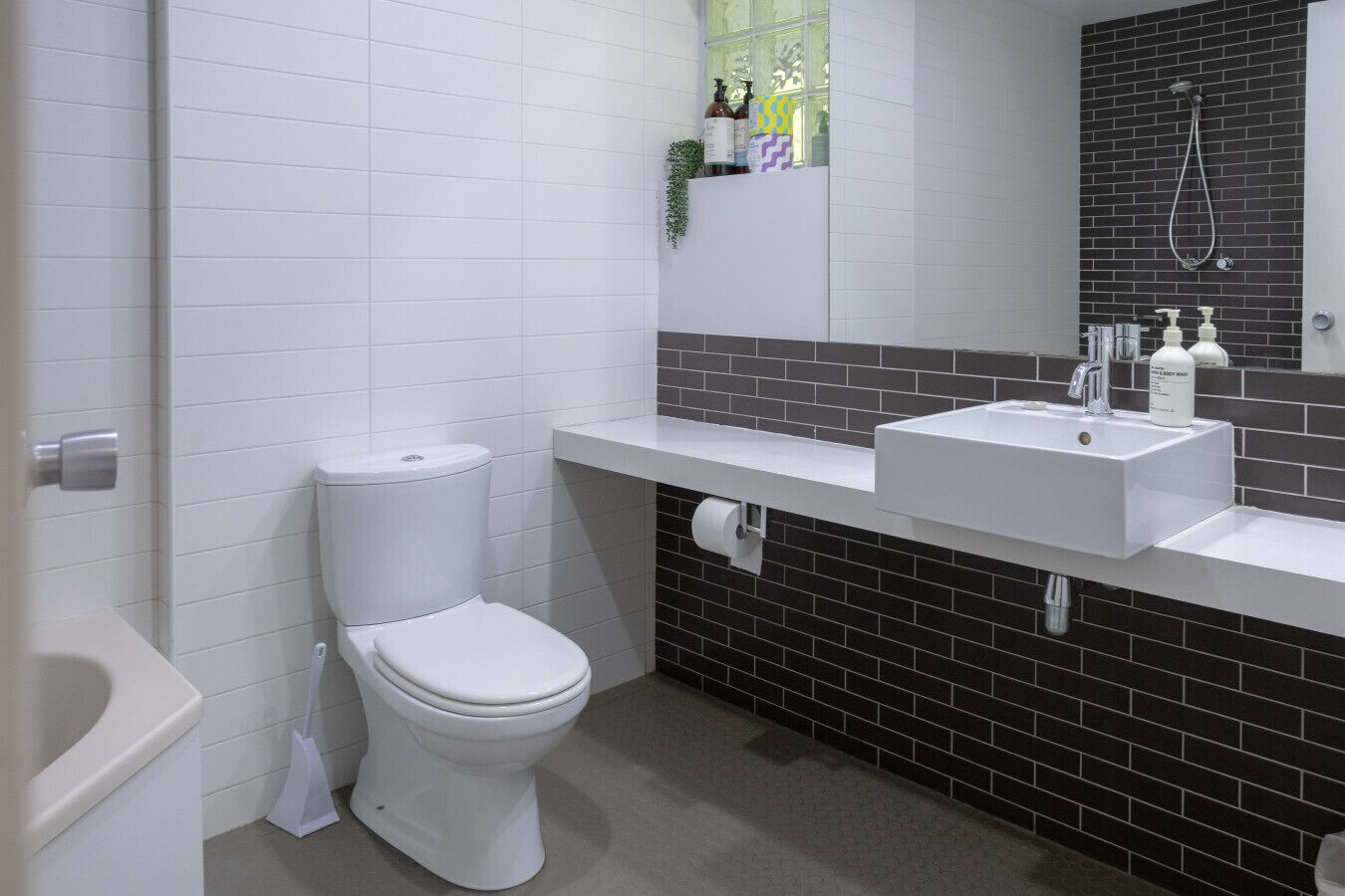 A modern bathroom with a toilet, sink, and shower.