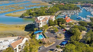 Een kusthotel met een zwembad, jachthaven en uitzicht op het water.