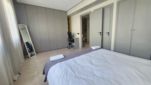 Une chambre d’hôtel moderne avec un grand lit, un bureau et une armoire.