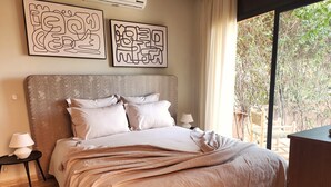 A bedroom with a large bed, two bedside tables, a lamp, and artwork on the wall. - Dar Bassidi by IB Signature - Luxury 5BR Villa -Heated Pool & Breakfast included (Marrakesh)