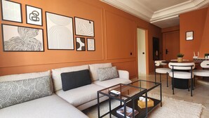 Ein modernes Wohnzimmer mit einer Couch, einem Couchtisch und Kunstwerken an der Wand.