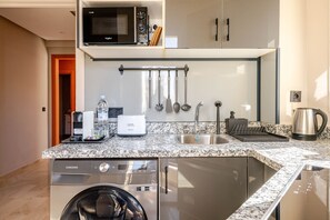 A compact kitchen with a microwave, coffee maker, and dishwasher. - The 23 Princesses (Casablanca)