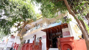A two-story building with a red entrance gate, a balcony on the upper floor, and a sign for 'Basil Inn' on the right side. - Basil Inn near To Taj Mahal (Agra)