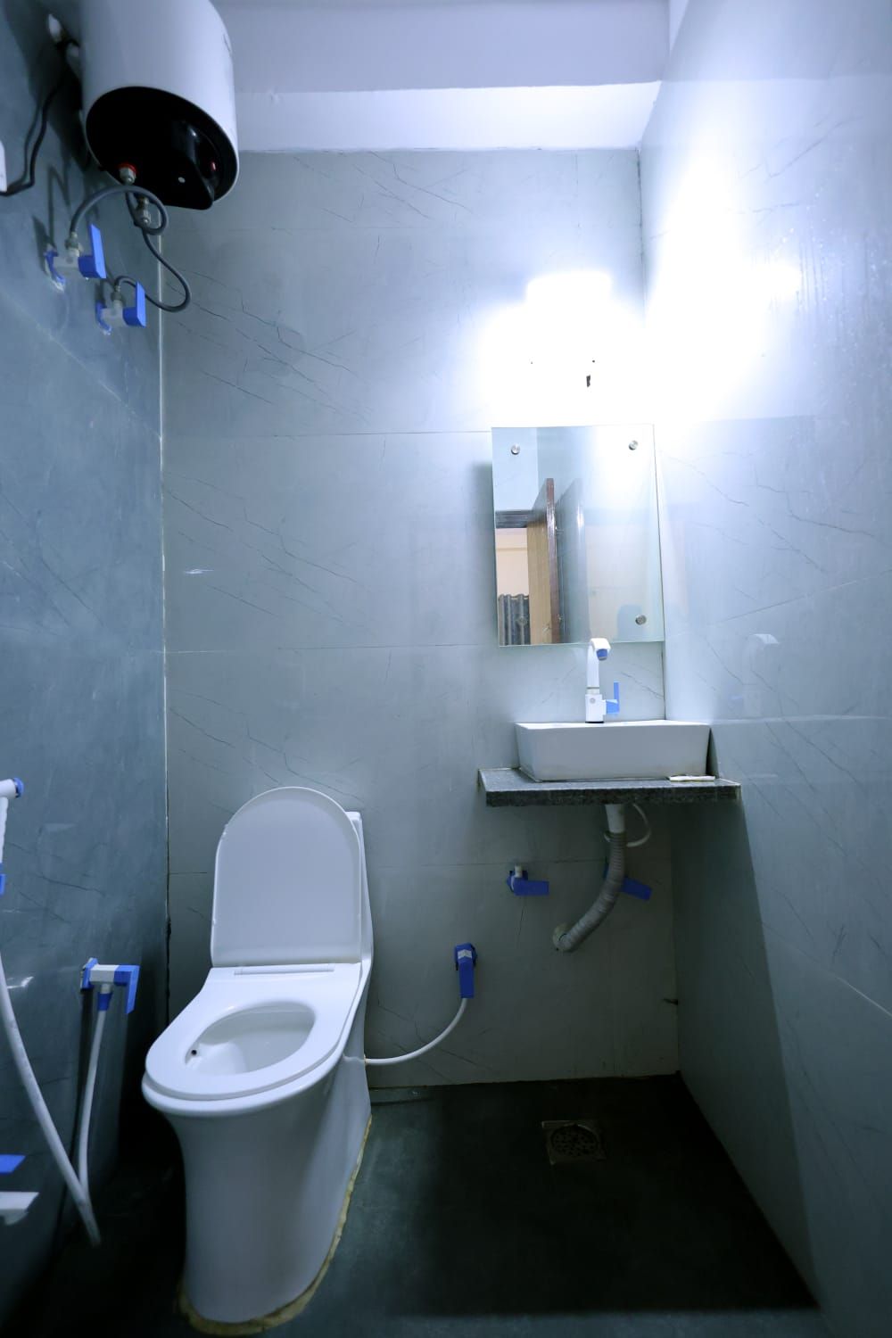 A small, compact bathroom with a toilet, sink, and mirror.
