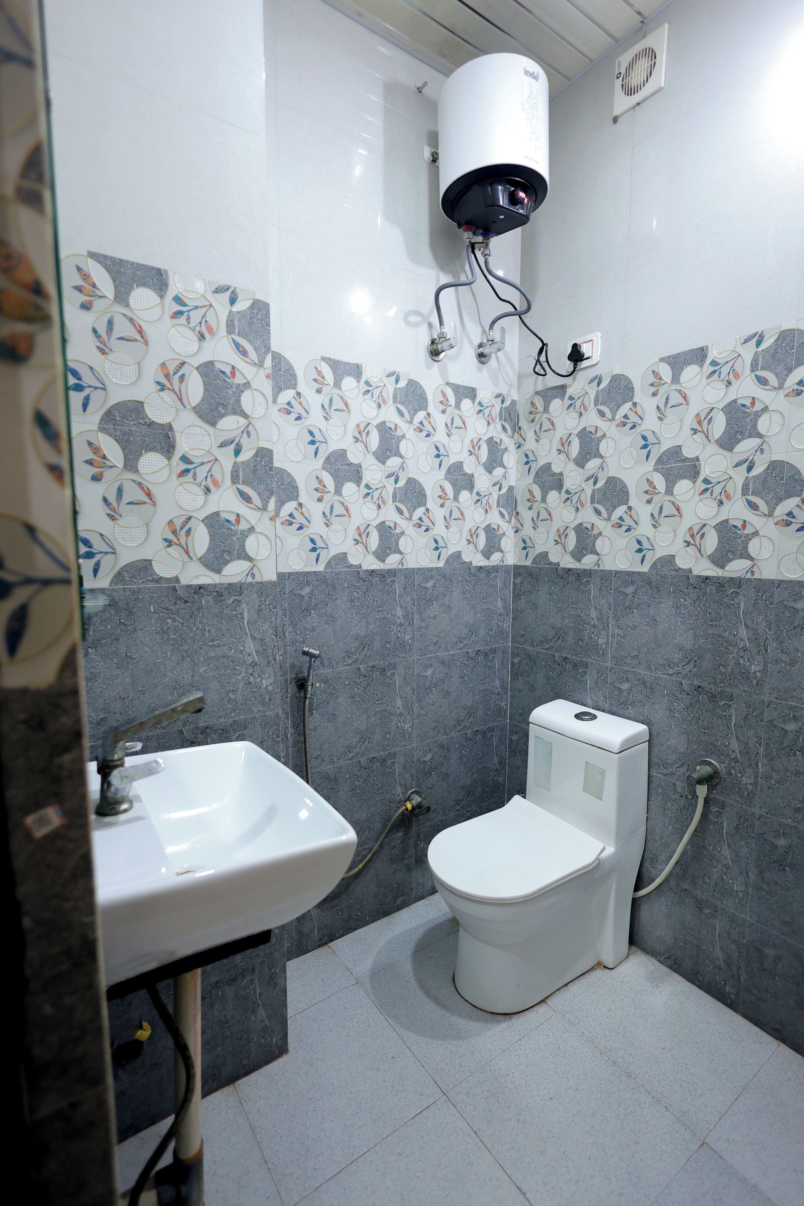 Un baño con inodoro, lavamanos y calentador de agua.