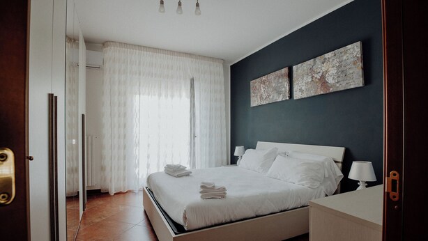 Un dormitorio con cama, mesitas de noche y una obra de arte en la pared.