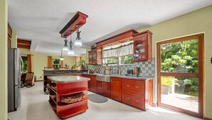 Una cocina amplia con una isla grande, armarios de madera y una puerta corrediza de vidrio al exterior.