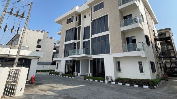 A multi-story building with a modern architectural design, featuring large windows and balconies.