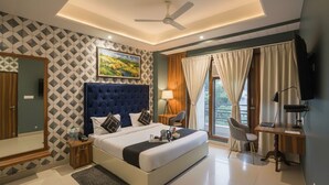 A modern hotel room with a large bed, a desk, a chair, and a TV. - Hotel Church House - Rohini I Near Metro I Spacious Rooms I Friendly Staff I Most Preferred Hotel In Rohini (New Delhi)