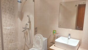 A bathroom with a shower, toilet, sink, and a mirror. - Eennra Maanikko (Krishnanagar)