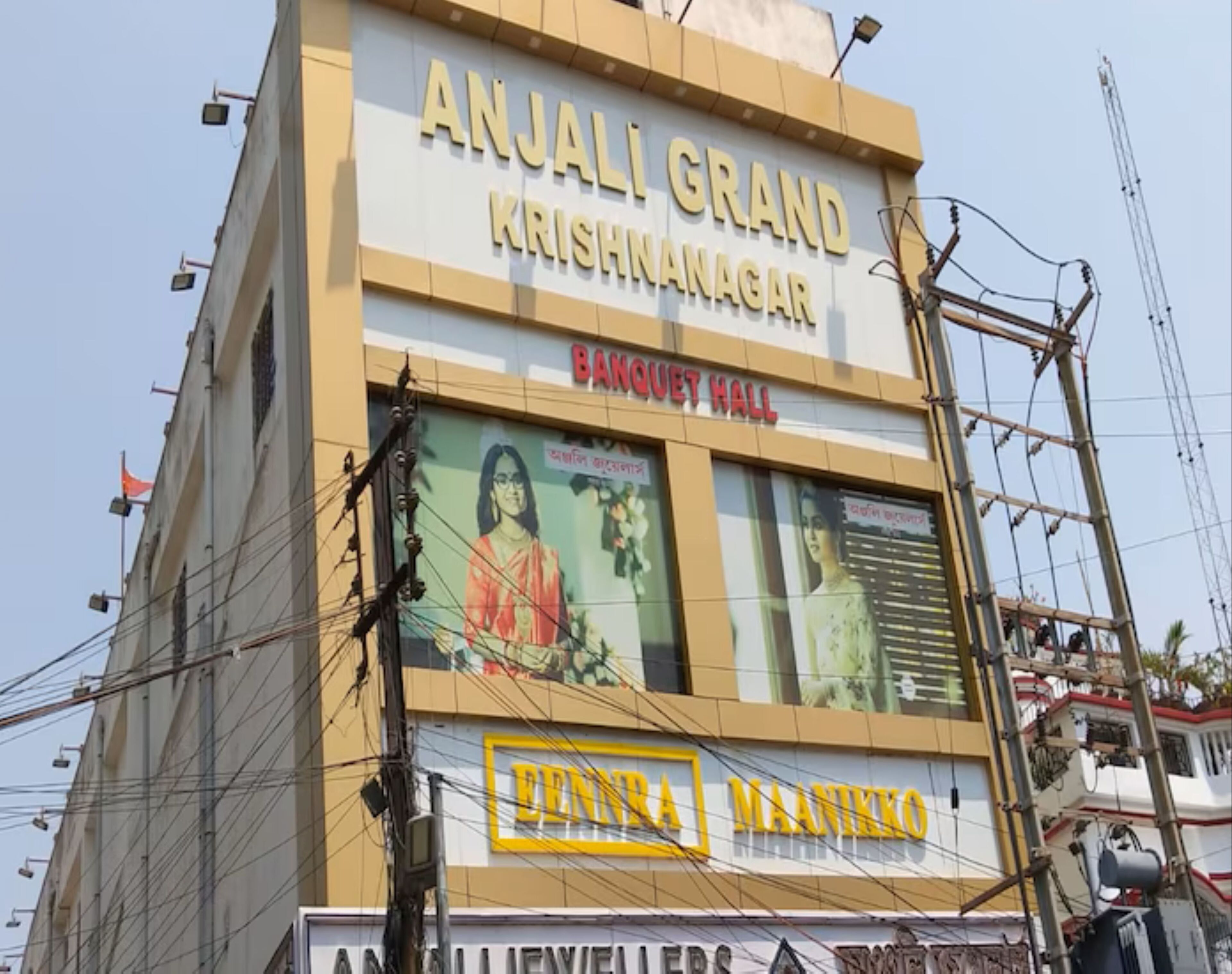 Un edificio con los rótulos 'ANJALI GRAND KRISHNANAGAR' y 'BANGUET HALL', que indica un hotel o salón para eventos.