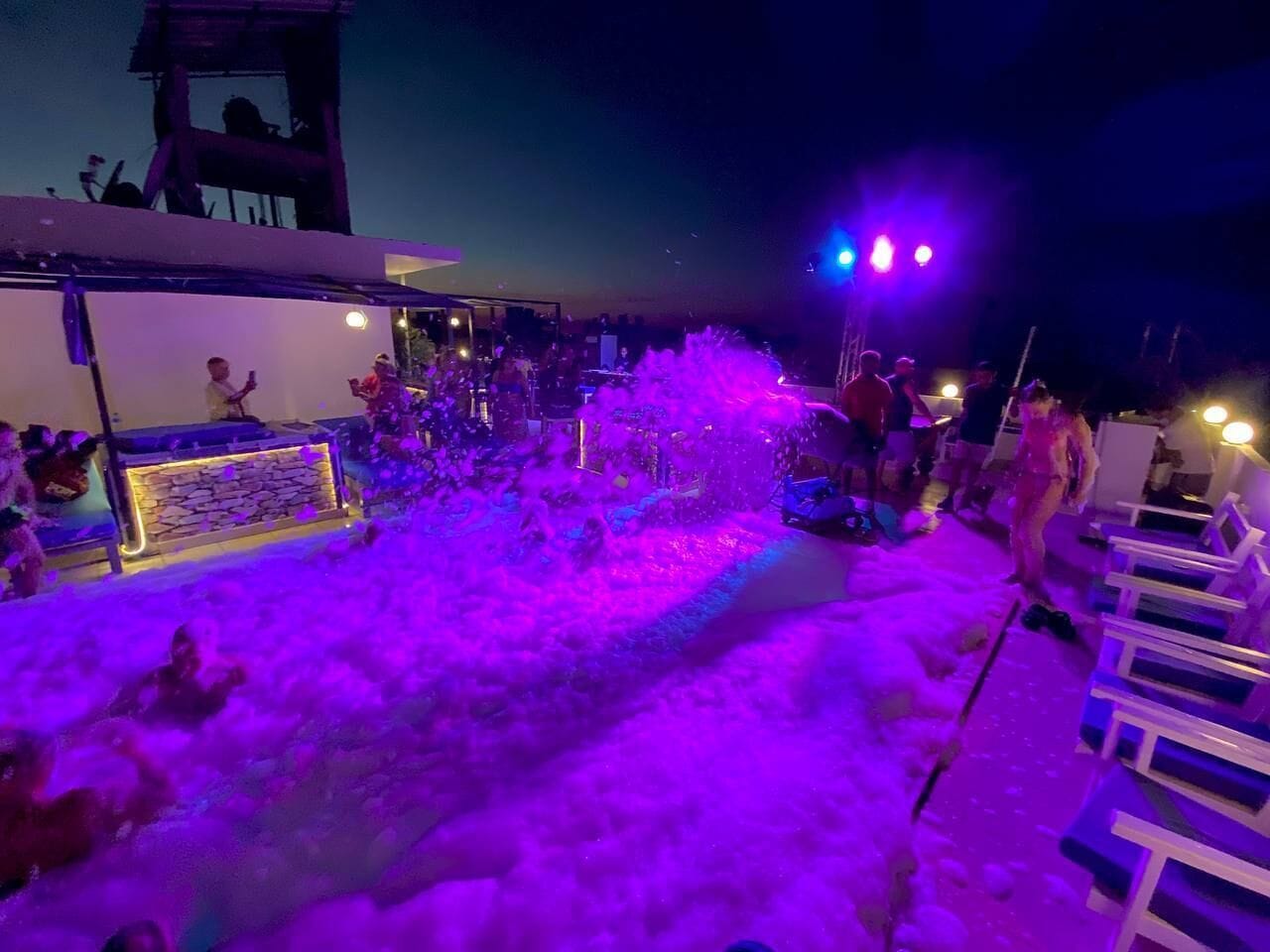 Zona de piscina con tobogán y escenario para música en vivo.