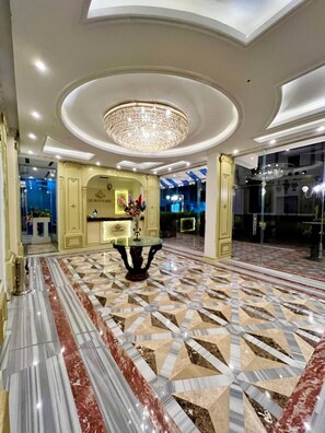 A lobby with a marble floor, a chandelier, and a reception desk. - La Boutique Residence  (Hurghada)