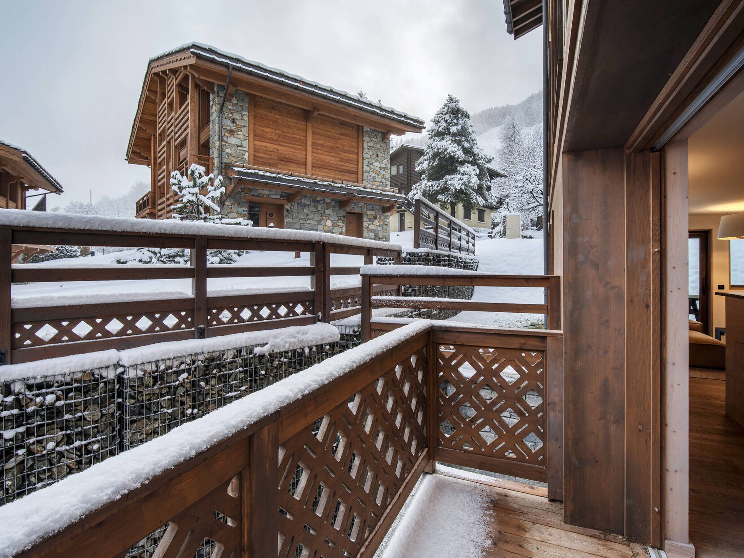 Un balcon en bois avec un mur en pierre et une clôture en bois.