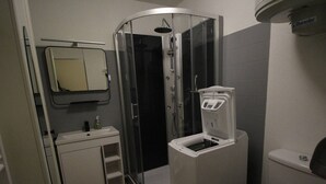A compact bathroom with a shower enclosure, a sink, a toilet, and a small storage cabinet. - Cozy apartment in Luchon, 4 ppl, near spa, with parking (Bagnères-de-Luchon)