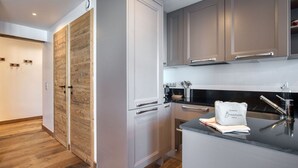 Eine moderne Küche mit grauen Schränken, einer Holzvertäfelung an der Wand und einer Arbeitsplatte mit Handtuch und Besteck.