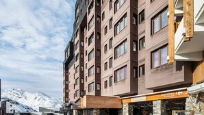 Ein mehrstöckiges Hotel mit Steinaußenwand und Holzelementen, mit Bar und Restaurant im Erdgeschoss.