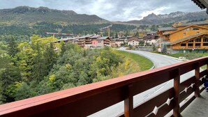 Et fjeldresort med træhuse, en snoet vej og en skovdal.