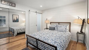 A bedroom with a large bed, two bedside tables with lamps, a mirror, and a 'LOVE' sign on the wall. - 3BR/2.5BA Incline Village condo, pool, fireplace (Incline Village)