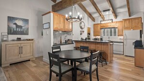 A spacious kitchen with wooden cabinets, a dining table with chairs, and a chandelier. - 3BR/2.5BA Incline Village condo, pool, fireplace (Incline Village)