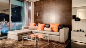 A modern living room with a sectional sofa, a glass coffee table, and a view of the city at night. - Studio • No Resort Fee • Free Parking • XR35 (Las Vegas)