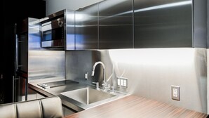 A modern kitchen with stainless steel appliances, a built-in oven, and a sleek faucet. - SVS: High Floor Mountain View Studio | Pool & Gym | Palms Place (Las Vegas)