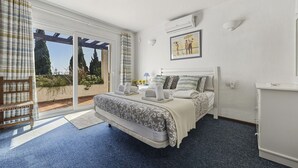 A bedroom with a bed, a desk, a chair, and a view of the outdoors. - 18 - Villa 1km from the beach in Calahonda/Mijas (Mijas Costa)