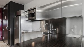 Una cocina moderna con electrodomésticos de acero inoxidable, una encimera de madera oscura y un microondas integrado.