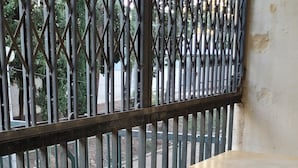 A balcony with a metal railing, a wooden table, and a tiled floor. - QUIET, SECURE F3 RENTAL WITH GARAGE (Nîmes)