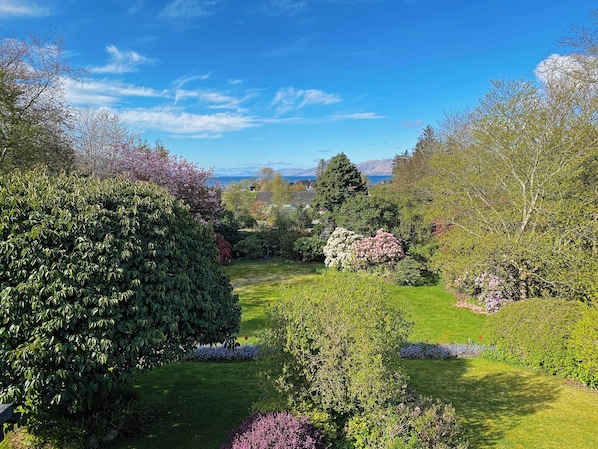 Un jardin bien entretenu, agrémenté de diverses plantes à fleurs et offrant une vue dégagée sur le paysage environnant.