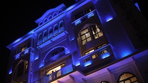 A multi-story building with traditional architectural design, featuring balconies and arched windows. - Hotel Shringar Mahal  (Vrindavan)