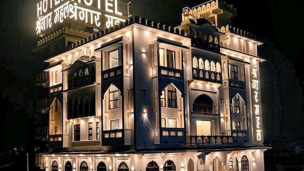 A multi-story hotel with illuminated signage and traditional architecture. - Hotel Shringar Mahal  (Vrindavan)