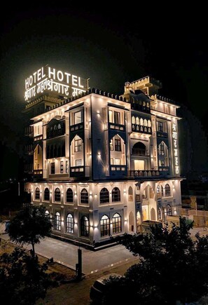 Ein mehrstöckiges Hotel mit beleuchteter Beschilderung und traditioneller Architektur.