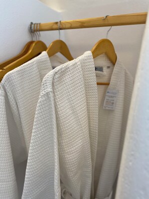 A wooden hanger rack with white towels. - Cave apartment with Hot Tub, sleeps 2, shared pool, near Fira. (Mesa Katikies)