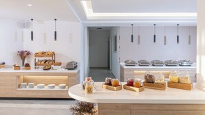 A breakfast buffet with various food items and a modern interior design. - Astra Village (Koutouloufari)