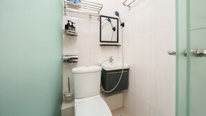 A small, modern bathroom with a toilet, sink, and shower. - Joy Hella Inn (Kowloon)