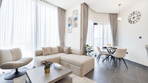 Een moderne woonkamer met een hoekbank, een eettafel met stoelen en een salontafel.