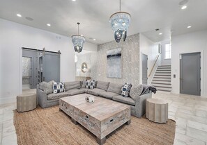 A modern living room with a sectional sofa, a wooden coffee table, and decorative lighting. - Gulf Views, Pvt Pool, Golf Cart, Steps To Beach! (Santa Rosa Beach)