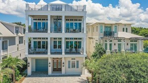A multi-story residential building with a central garage, balconies, and a clear sky. - Gulf Views, Pvt Pool, Golf Cart, Steps To Beach! (Santa Rosa Beach)