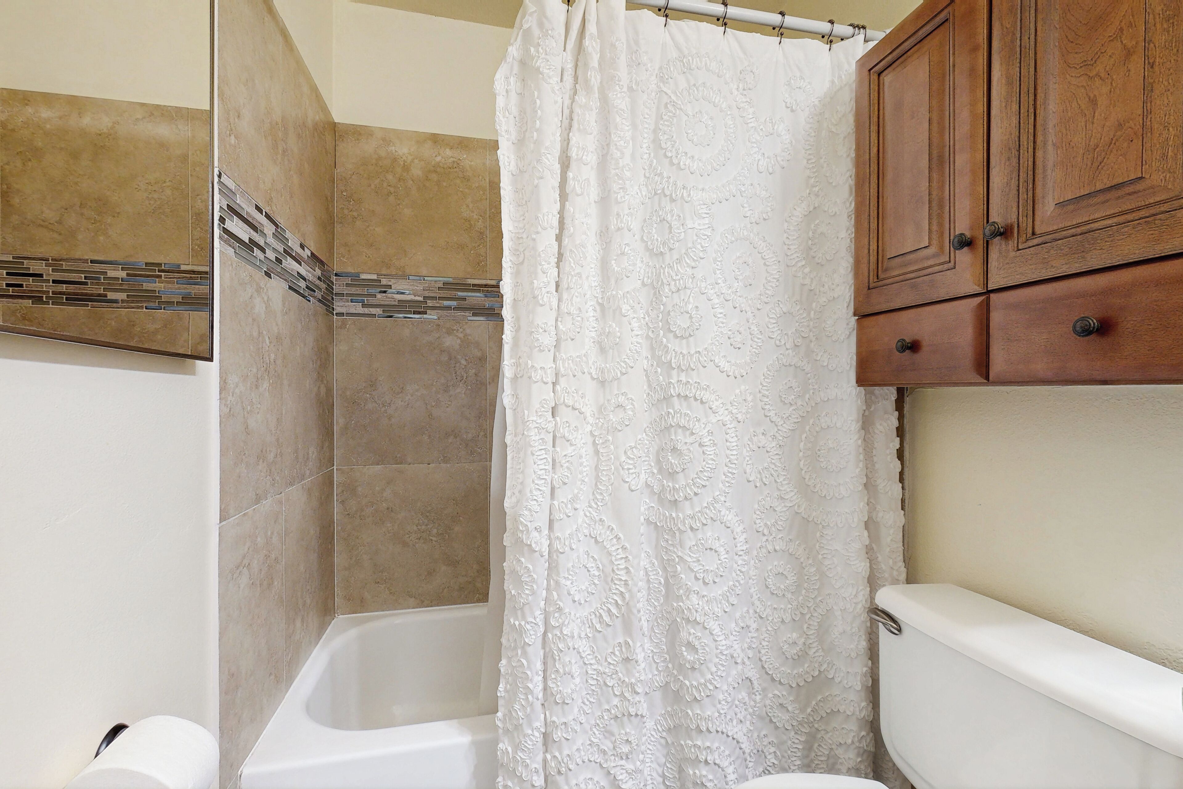 Une salle de bain avec une baignoire, des toilettes et des meubles en bois.