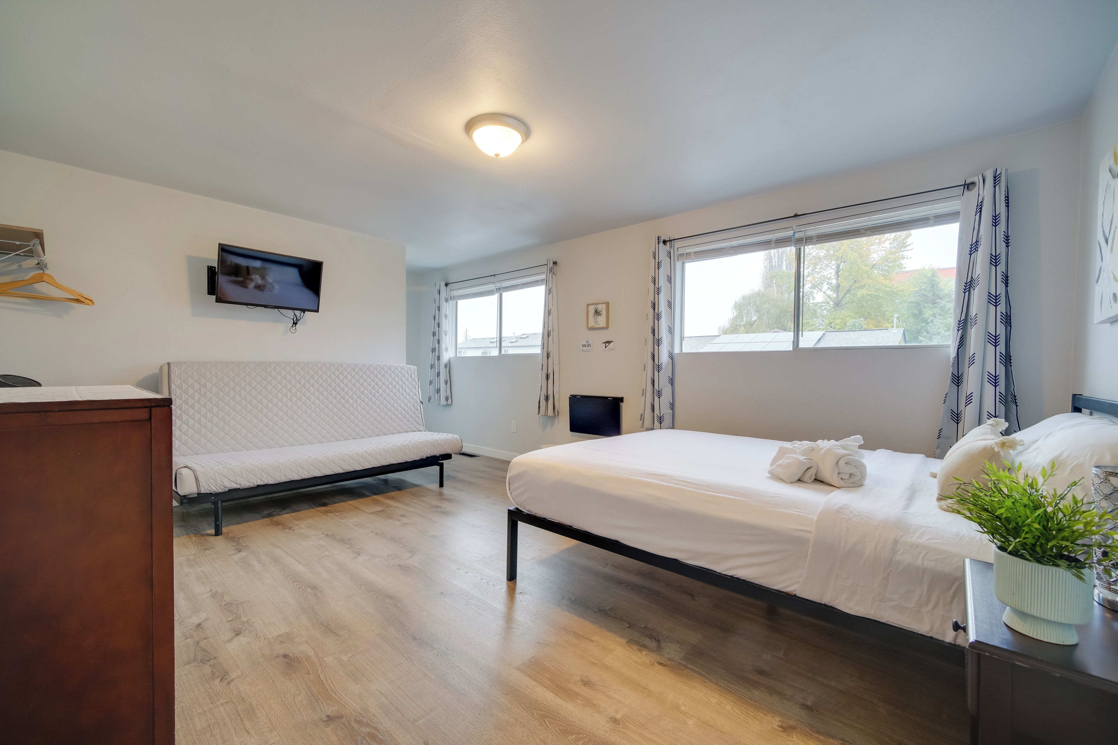 Une chambre avec un lit, un canapé, une télévision et une fenêtre.