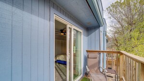 A room with a sliding glass door leading to a balcony with a small table and chair. - 5 Mi to Route 66 Fun! Tulsa Towhome w/ Game Room (Tulsa)