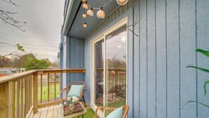 A covered patio with wicker chairs and a table, a wooden deck, and a glass door leading to a patio area. - Pet-friendly Retreat w/ Yard, 12 Mi to Dtwn Tulsa (Tulsa)