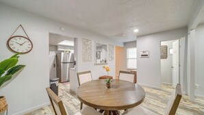 A dining area with a round wooden table, six chairs, and a clock on the wall. - Pet-friendly Retreat w/ Yard, 12 Mi to Dtwn Tulsa (Tulsa)