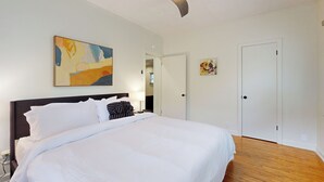 A hotel room with a large bed, a ceiling fan, and artwork on the walls. - Easy Access to Osu! 'marvin's Manor' in Stillwater (Stillwater)
