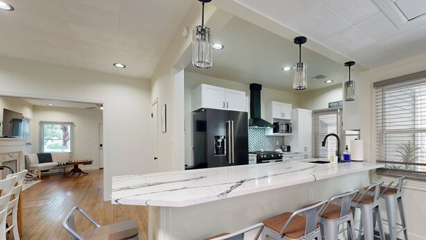 A modern kitchen with a marble island, stainless steel appliances, and bar stools. - Easy Access to Osu! 'marvin's Manor' in Stillwater (Stillwater)