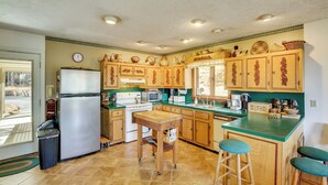 A kitchen with wooden cabinets, a refrigerator, a sink, and a window. - Ski, Hike & Unwind: Mtn-view Gem w/ Deck in Boone (Boone)