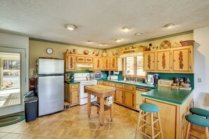 A kitchen with wooden cabinets, a refrigerator, a sink, and a window. - Ski, Hike & Unwind: Mtn-view Gem w/ Deck in Boone (Boone)