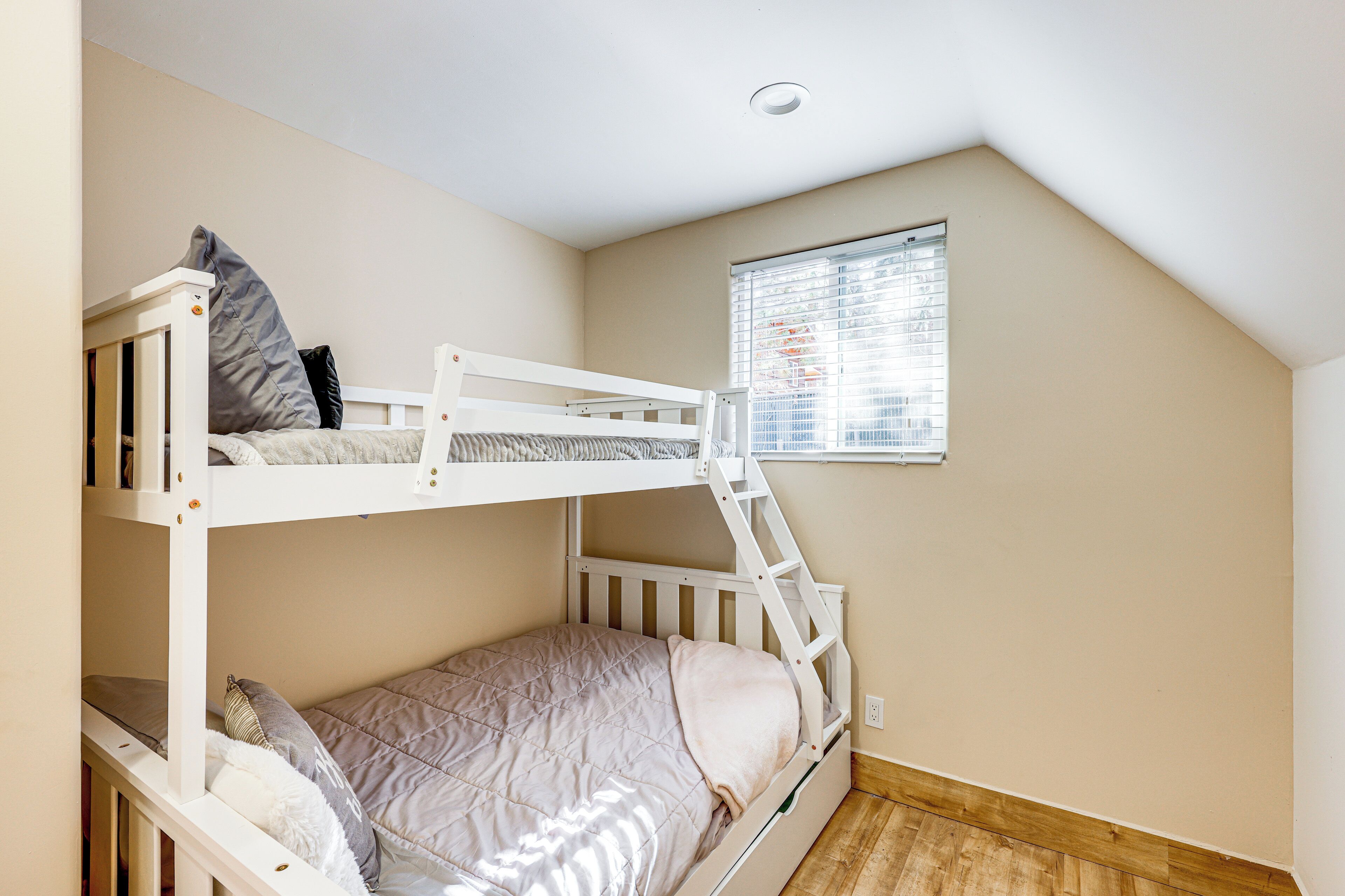Dormitorio con literas, ventana y luz en el techo.
