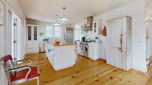 A spacious kitchen with wooden flooring, white cabinetry, and a central island. - Close to Copake Lake! 4-season Escape w/ Sauna (Copake)